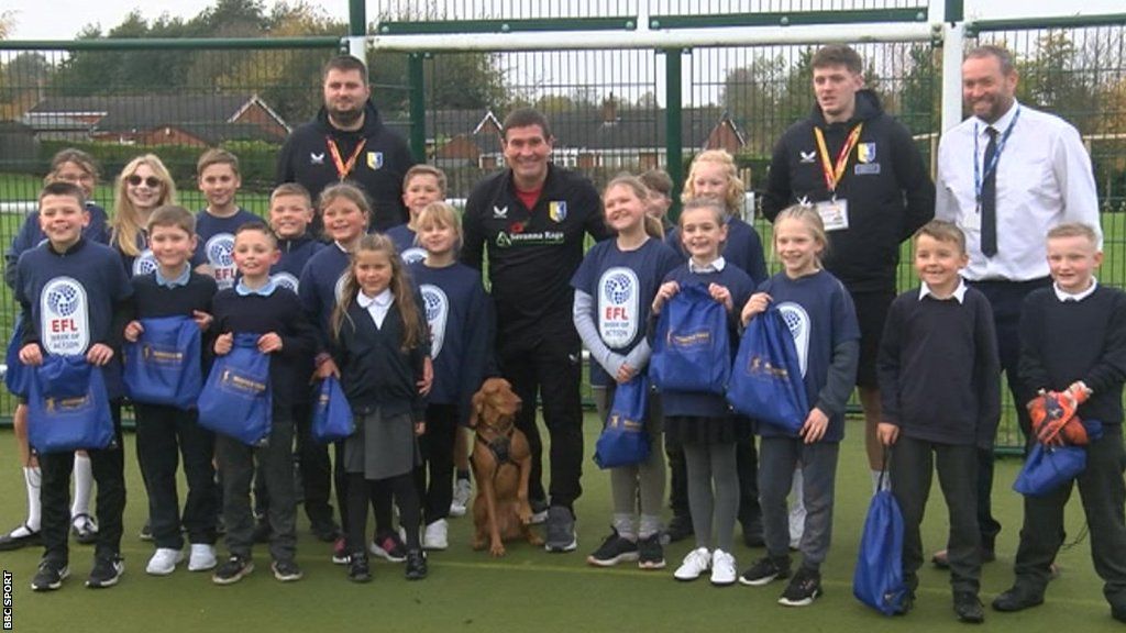 Nigel Clough and his dog Bobbie (centre) with pupils, teachers and Mansfield Town Community Trust coaches at St Andrew's Primary School