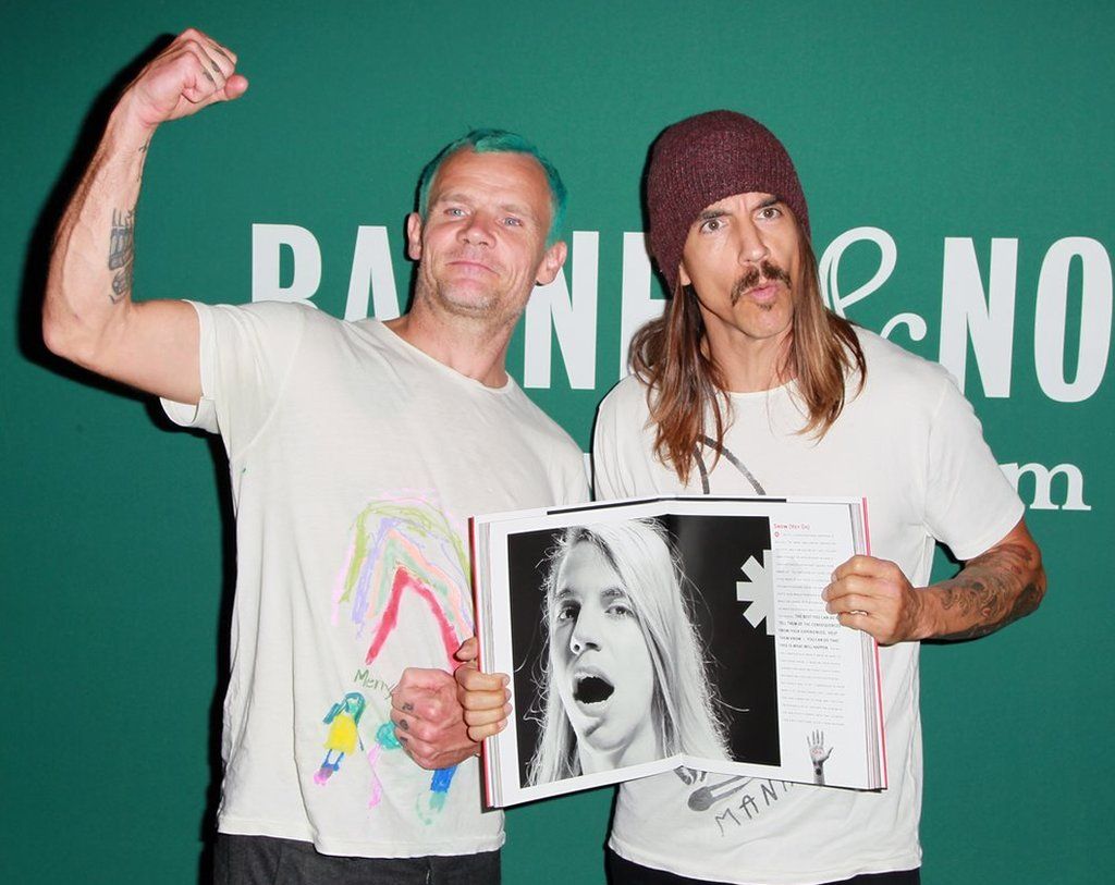 Flea and Anthony Kiedis hold a biography of the Red Hot Chili Peppers
