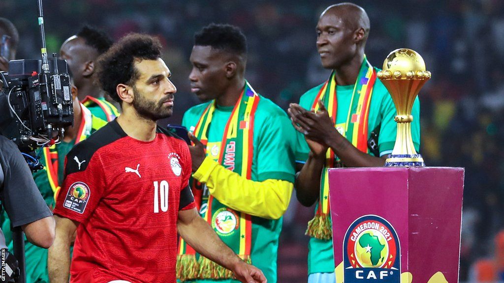 Mohamed Salah walks past the Africa Cup of Nations trophy following the final of the 2021 tournament against Senegal