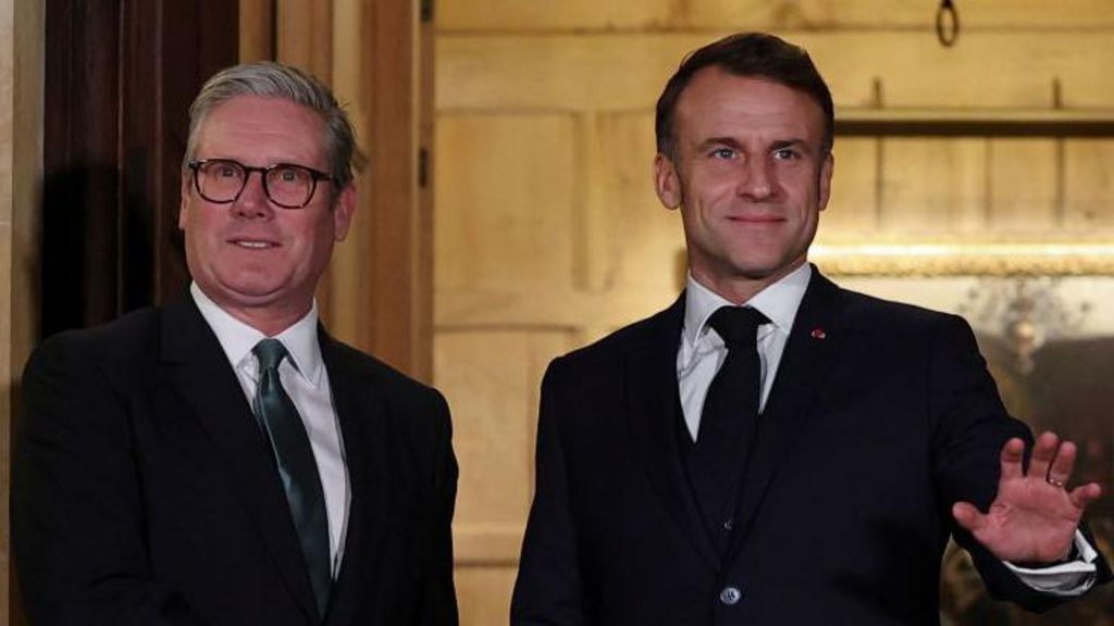 British Prime Minister Keir Starmer and French President Emmanuel Macron, both wearing suits and ties, stand next to each other as they pose for photographers