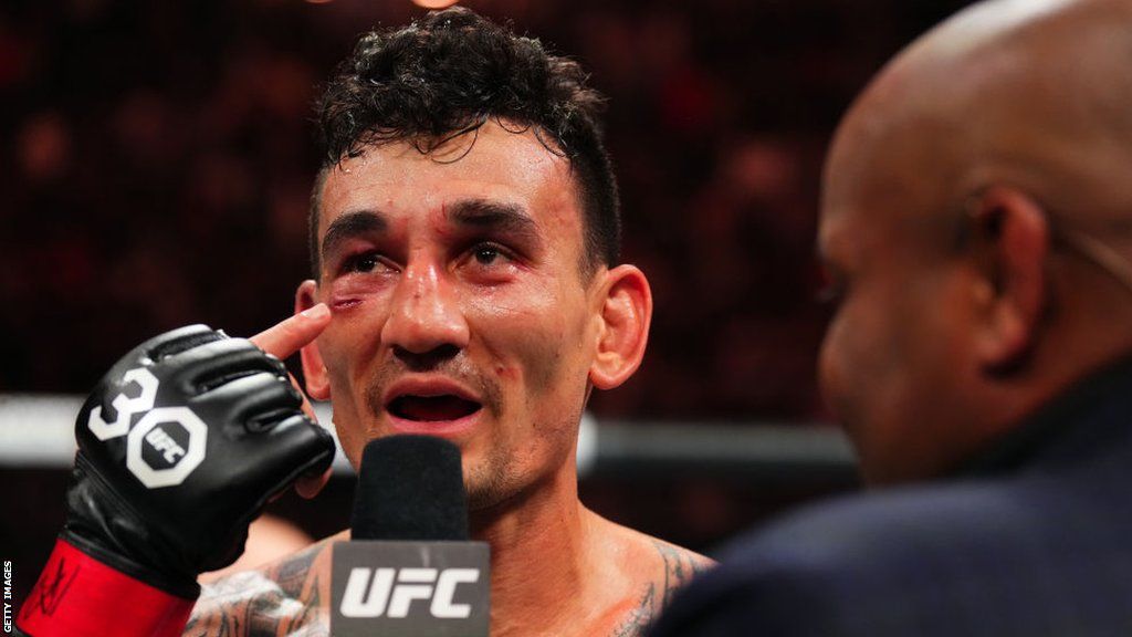 Max Holloway points to the cut below his right eye opened up by Arnold Allen