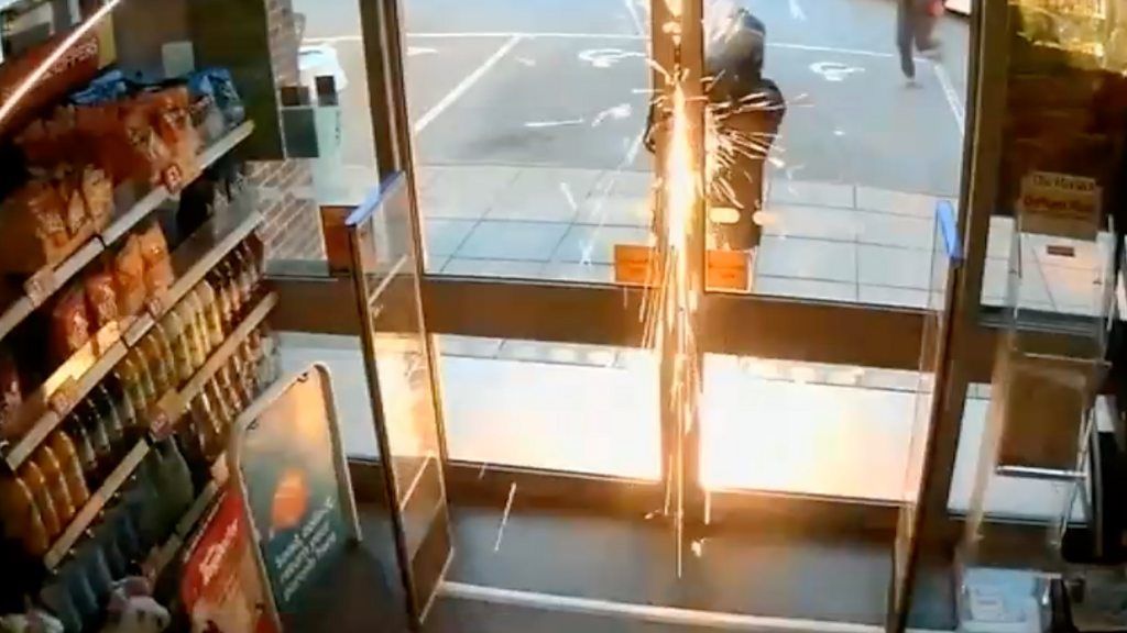 Sparks fly from a saw as it cuts a door lock