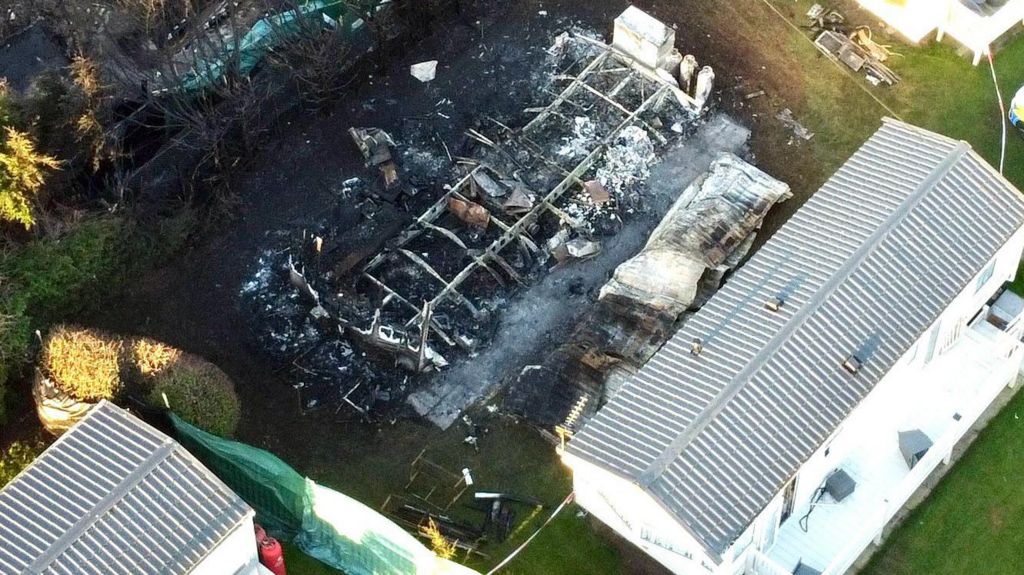Other caravans surround the burnt out remains in a still taken from drone footage.
