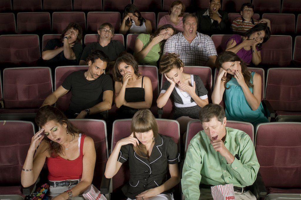 Stock image of an audience yawning and looking bored