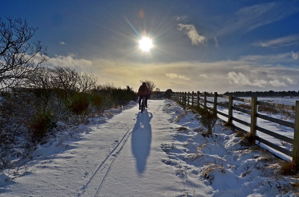 Cycling in the snow along the C2C cycle route near Waskerley, Consett in County Durham