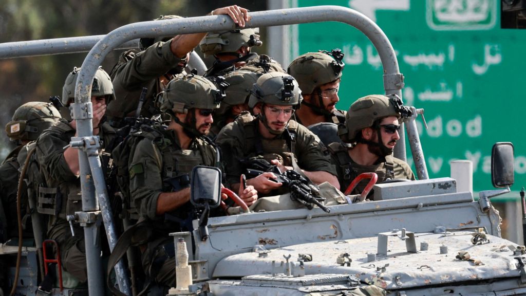 Israeli troops drive on a jeep in southern Israel during Hamas's 7 October 2023 attack on Israel