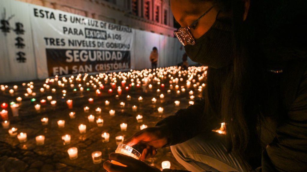 A journalist lights a candle with candles in background