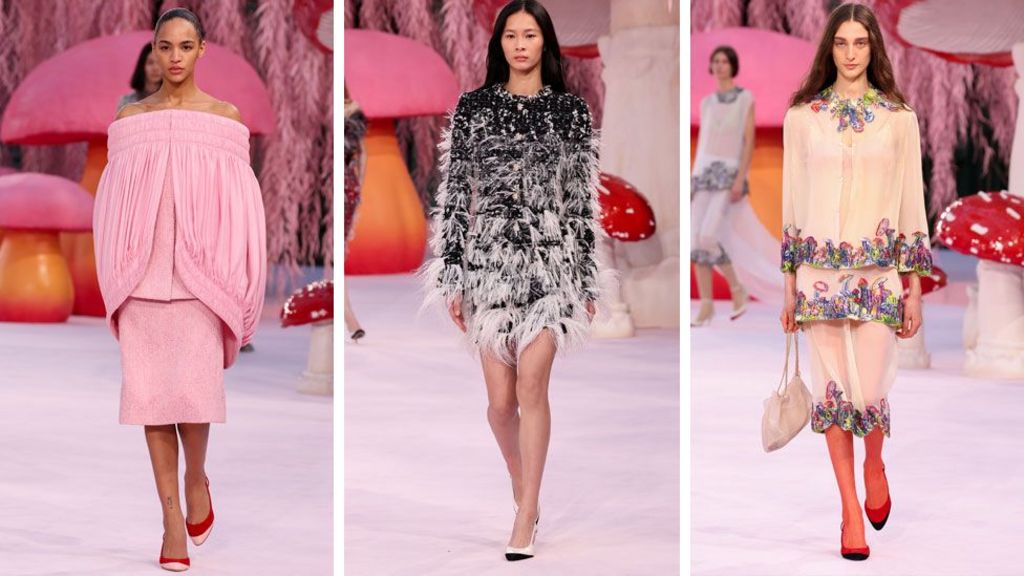 Three models on a Chanel catwalk - one wears a pale pink suit with an off-the-shoulder top with draped cape shoulder detail, one has a feathered black and white dress and the third a sheer embroidered suit