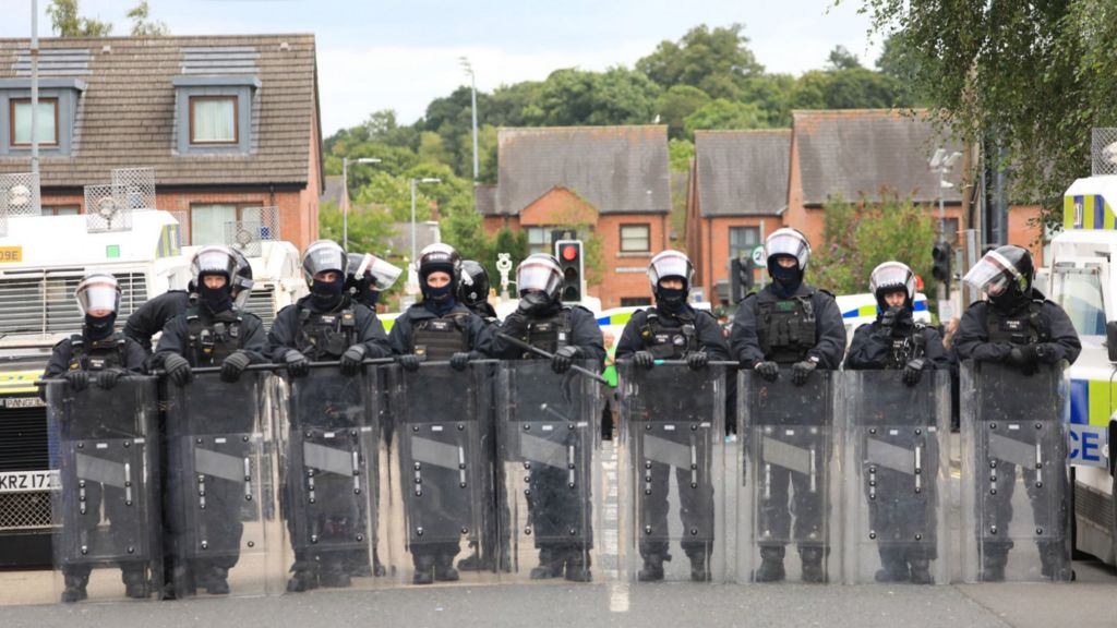 Riot police form a line after people taking part in an anti-Islamic protest make their way through the area following a protest outside Belfast City Hall