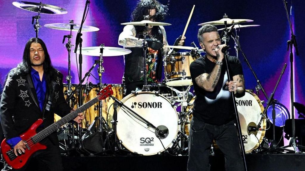 Robbie Williams performs with Adam Wakeman, Robert Trujillo, Tommy Clufetos and Zakk Wylde in tribute of Ozzy Osbourne during the Brit Awards 2026 at Co-op Live, Manchester