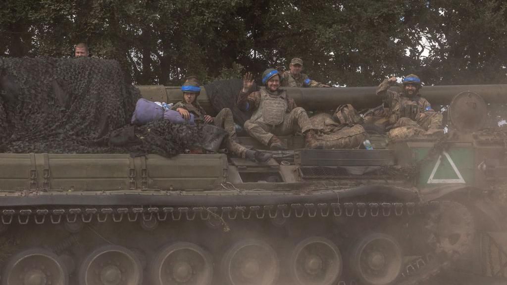 Ukrainian soldiers sit on an armoured vehicle near the Russian border