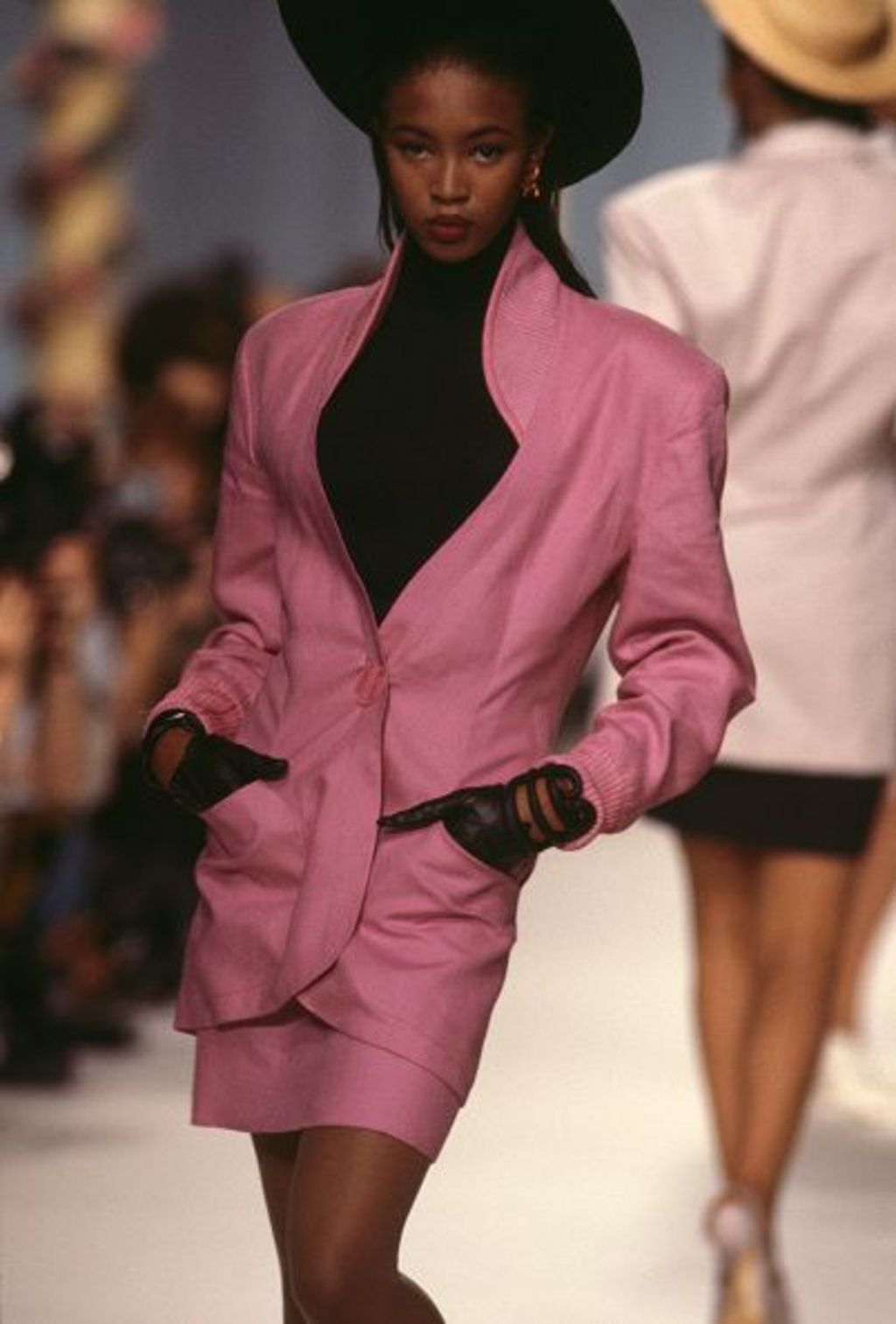 Naomi Campbell wearing a pink blazer and matching mini-skirt at a Karl Lagerfield fashion show in 1987