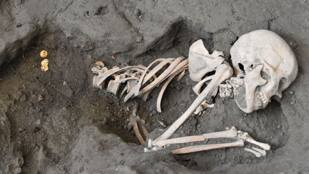 Skeleton of a woman and gold coins