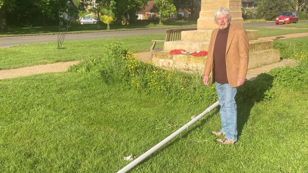 Jon Gambold by a flag that has been cut down in Biddenham, Bedfordshire