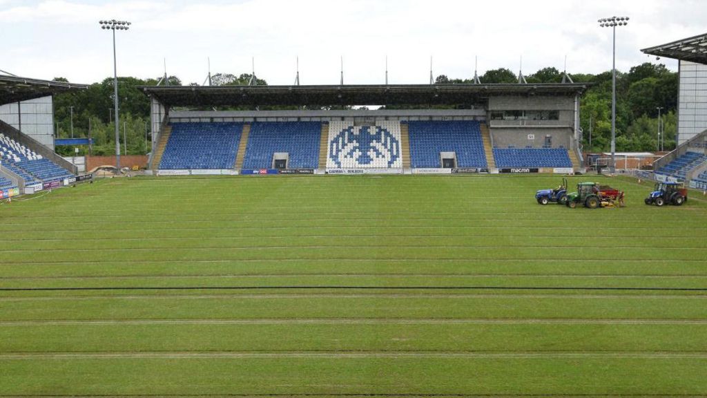Vehicles on the pitch at Colchester United's home ground