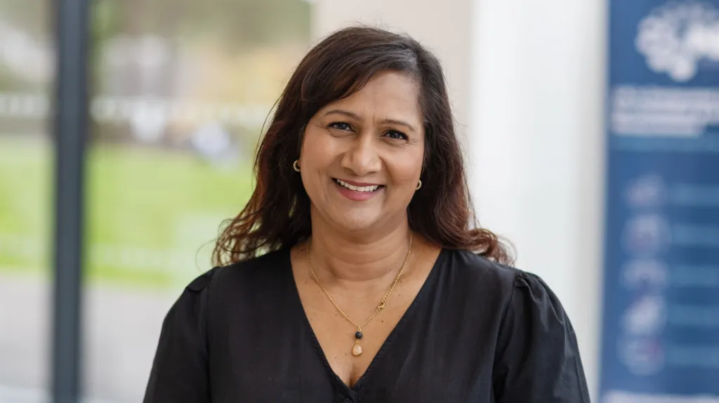 Wearing a black top Dr Selvarani Elahi, smiles and looks into the camera.