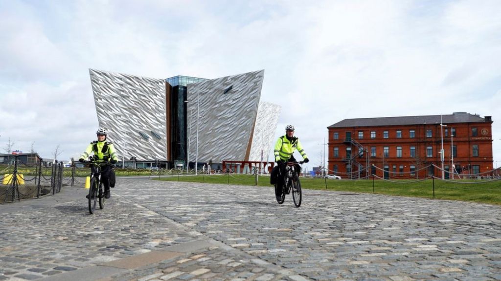 Police officers on bikes are seen in front of the Titanic Belfast Museum in Belfast Harbour, as the spread of the coronavirus disease continues