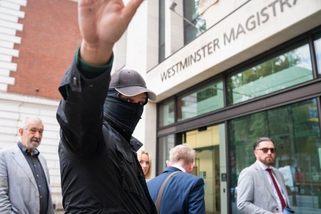 Thomas Phillips arrives at Westminster Magistrates Court wearing a balaclava, baseball cap and black coat.