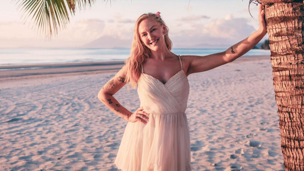 A picture of Helen in a white dress on a beach