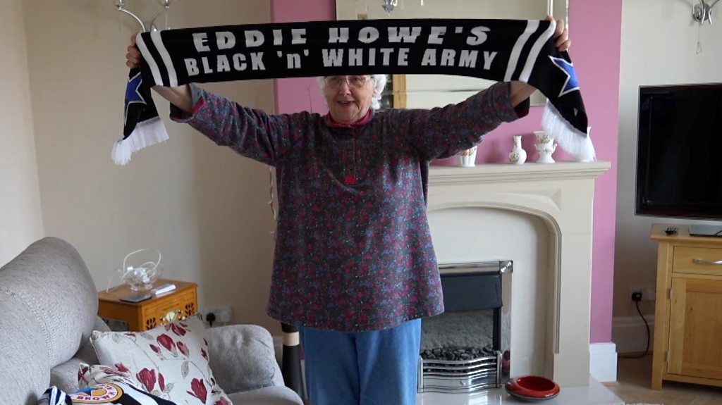 Doris Binks, a lifelong NUFC supporter proudly holds up her black and white scarf