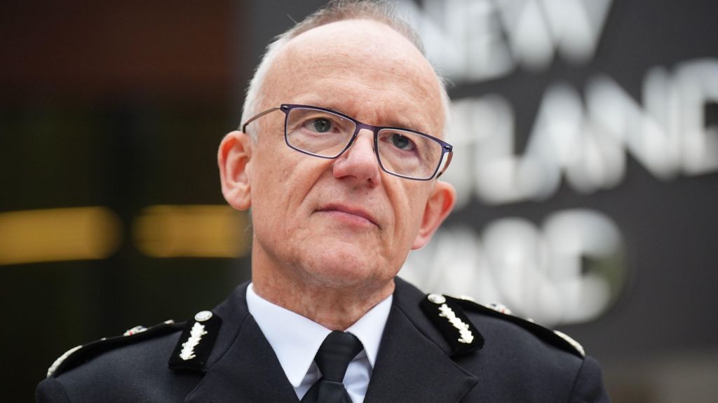 An image of Sir Mark Rowley standing outside New Scotland Yard in his uniform