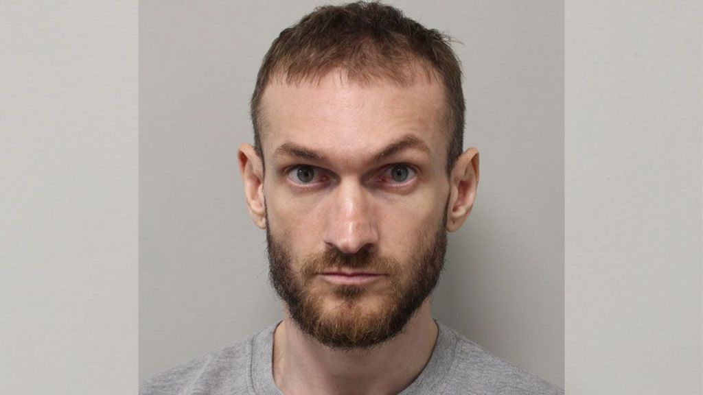 Custody mugshot of Marcus Monzo wearing a grey top