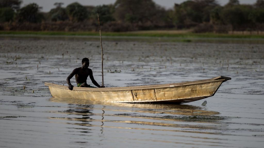 A lone fisherman steers his boat on Lake Chad