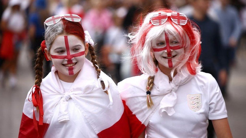 Two young girls with the England flag painted on their faces arrive at Wembley Stadium