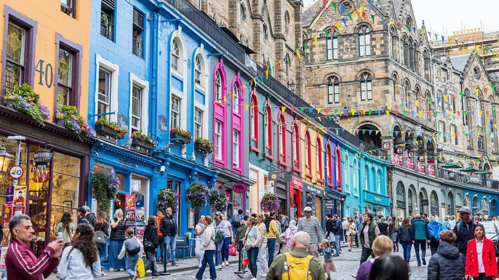 tourists walking down a colourfully-painted street in Edinburgh