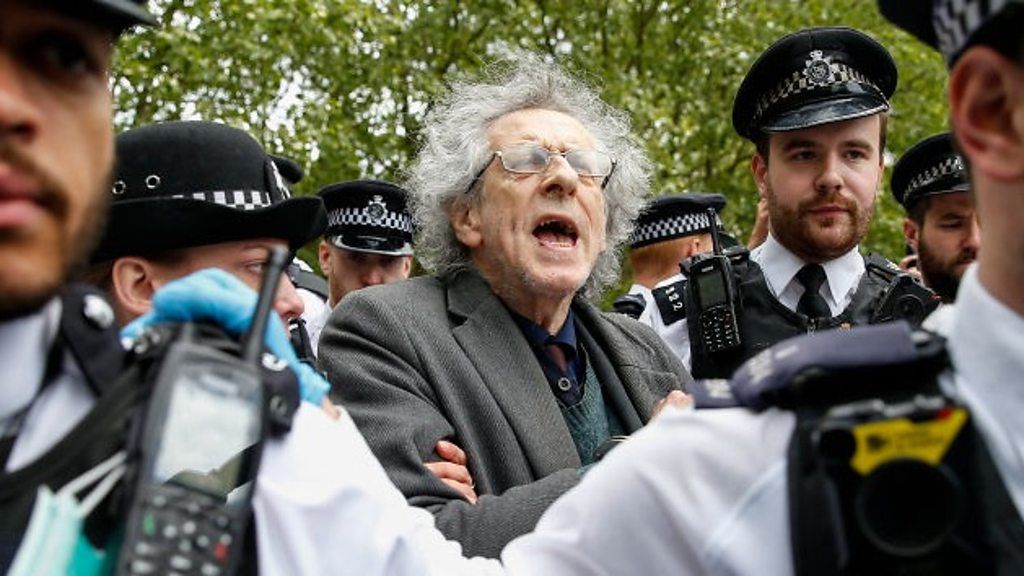 Piers Corbyn surrounded by police officers
