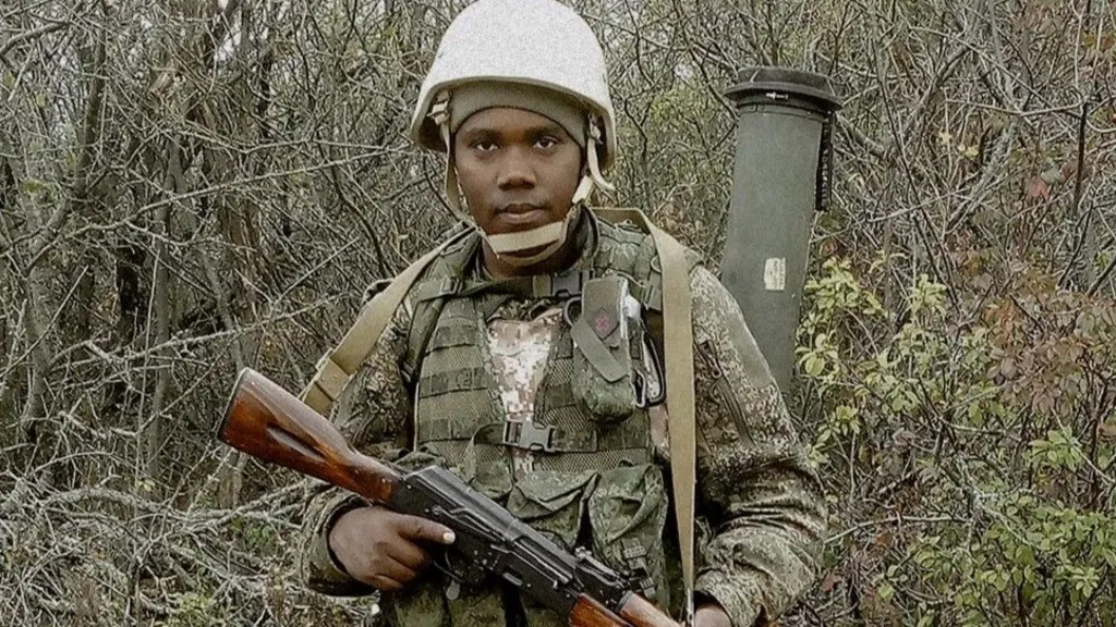 Clinton Nyapara Mogesa, in military uniform, holding a rifle 