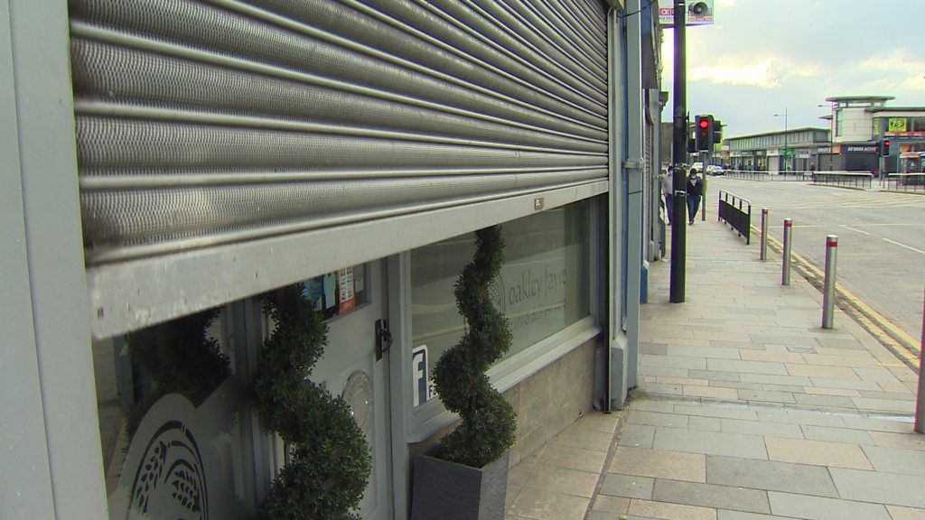 A closed shutter on the front of a shop
