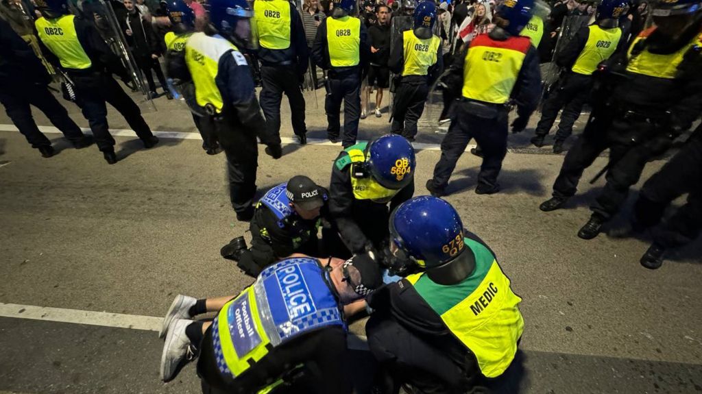 Police officers detain some far-right protesters after they tried to cross to the side of the opposing group in Plymouth