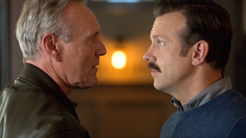 Head facing and speaking to Jason Sudeikis in a scene from Ted Lasso 