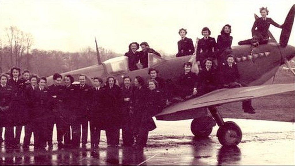 A group of women posing with a spitfire at Hamble Airfield in Southampton