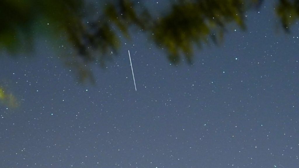 A Starlink satelllite appears as a streak of light in the early evening sky