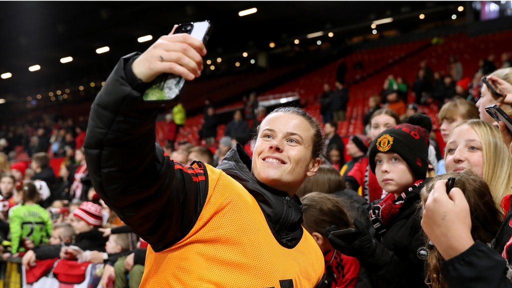 Hayley Ladd of Manchester United poses with fans at the end of the WSL derby against Manchester City at Old Trafford on November 19, 2023