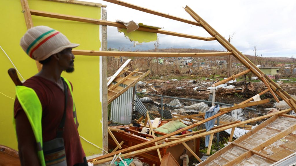 A man looks out over a large area of debris 