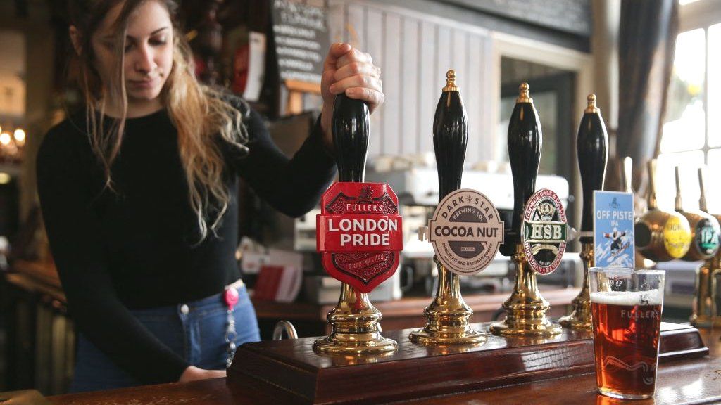 Bartender pulling a pint in a Fuller's pub