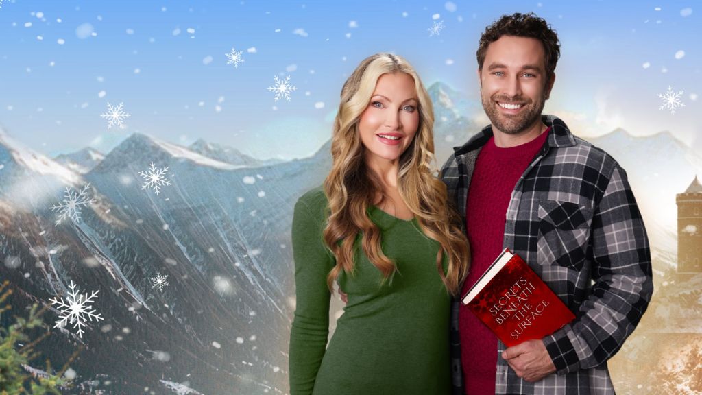 Caprice Bourret and Alex Trumble standing close together in front of a backdrop of Scottish mountains and snowflakes