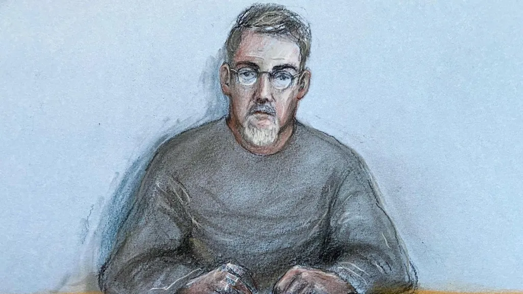 A court sketch of a man in a grey sweatshirt and glasses.