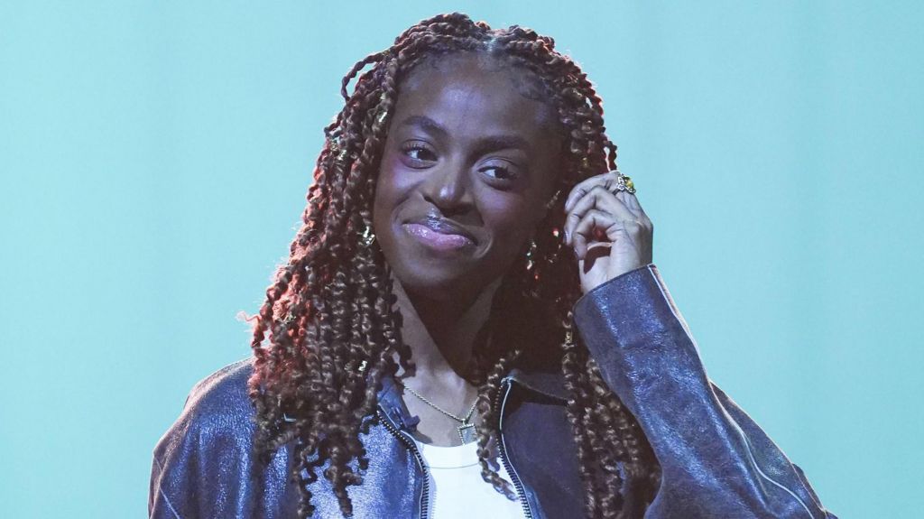 Cat Burns pictured smiling and wearing a leather jacket during filming for the Graham Norton Show in December