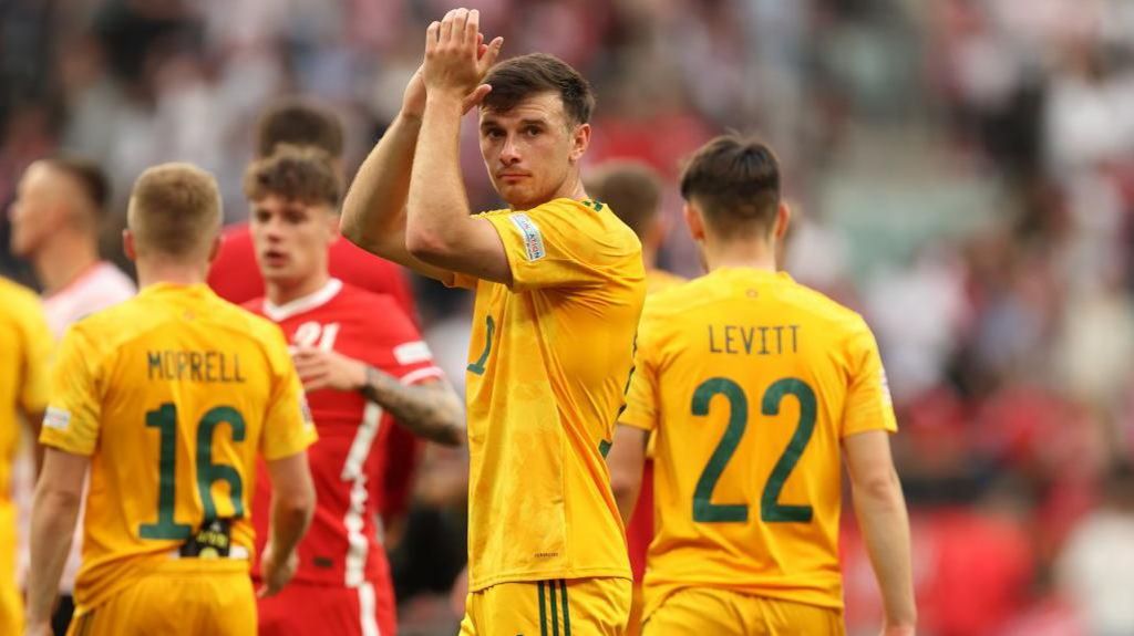 Mark Harris applauds the fans at full-time of Wales' defeat in Poland in 2022