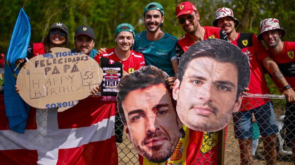 Fans at the Spanish Grand Prix hold up giant cardboard heads of Carlos Sainz and Fernando Alonso 