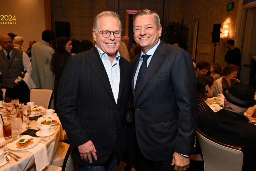 David Zaslav, chief executive, Warner Bros Discovery and Ted Sarandos, chief executive, Netflix smile in dark pin-stripe suits