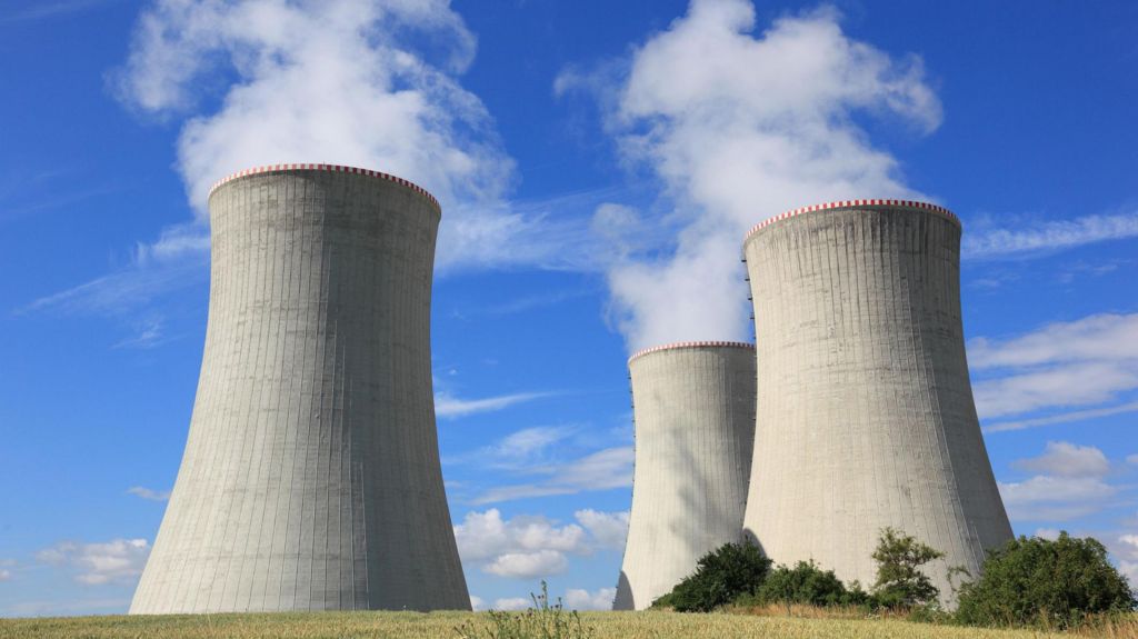 Three large power plant chimneys pumping out steam