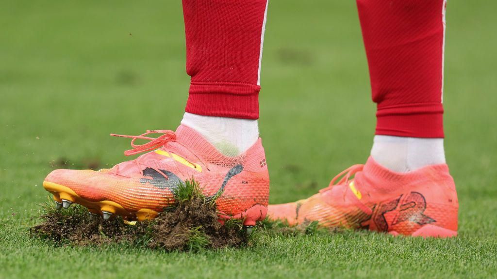 A player puts his football boot on a lump of grass