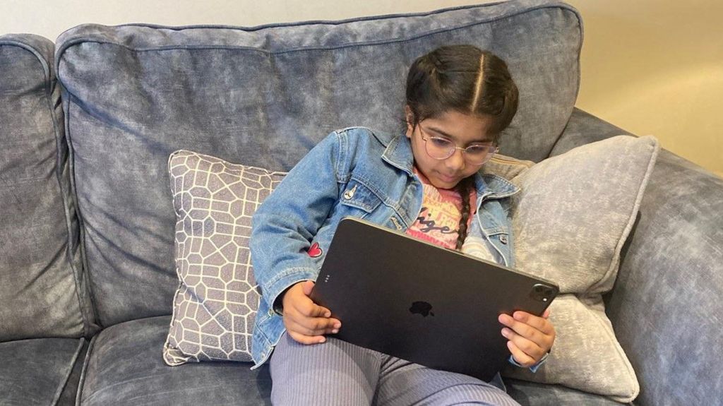 Seven-year-old Aishwarya, from Leeds, looks at a digital screen