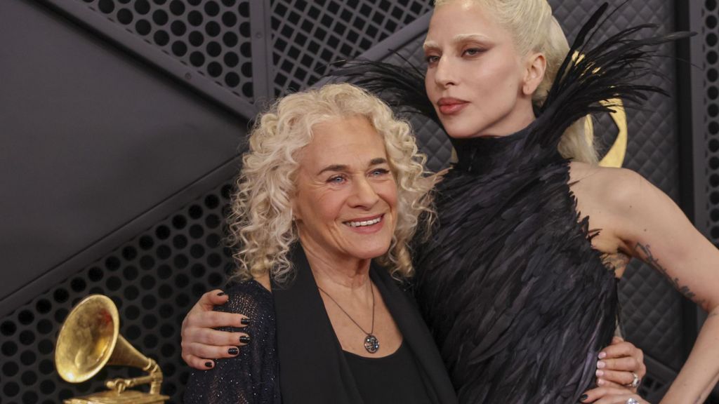 Carole King and Lady Gaga with their arms around each other on the red carpet