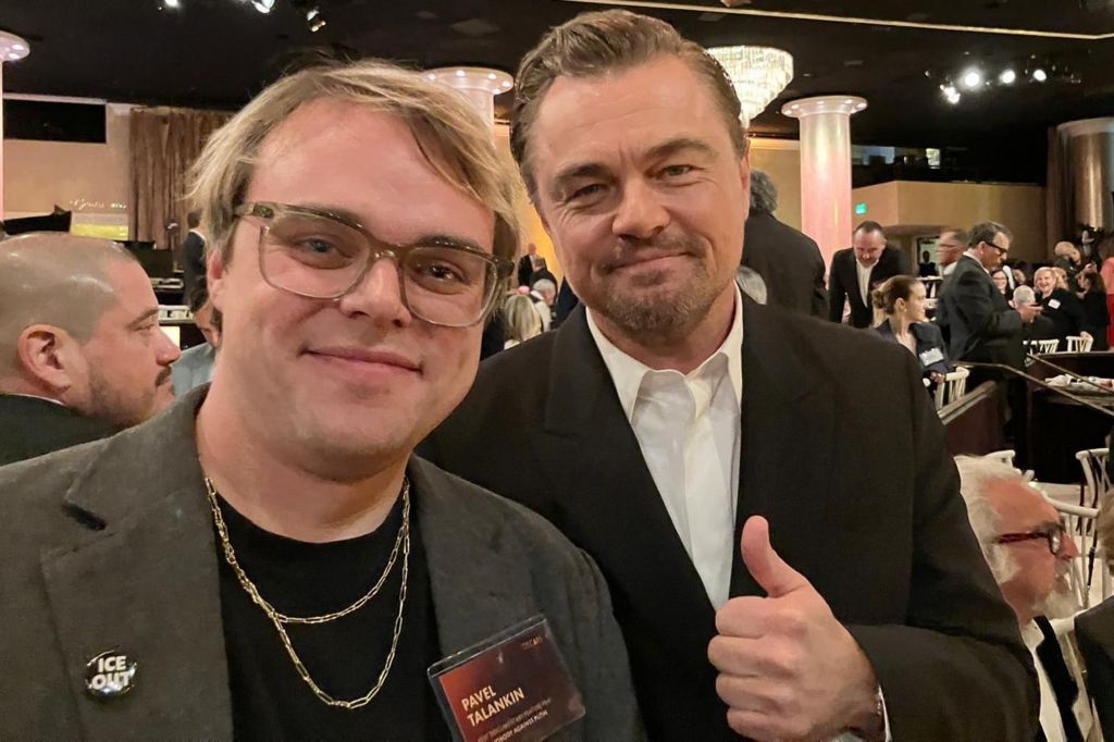On the left - Pavel Talankin smiling, with glasses, khaki jacket & black top & gold chain
On the right -- Leonardo DiCaprio, smilnig, dark jacket, white shirt, giving a thumbs up